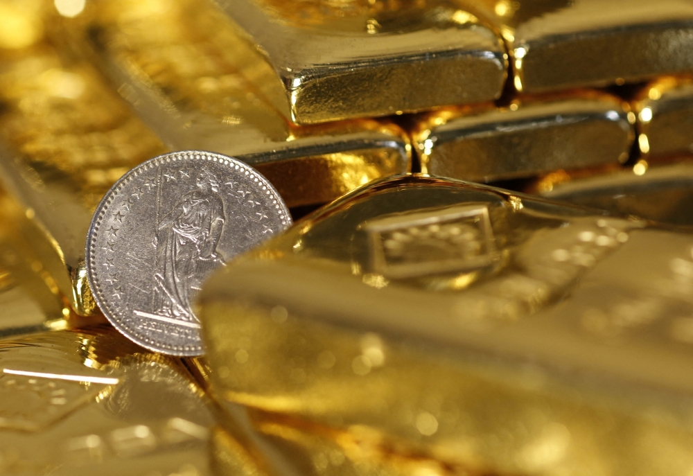 Gold bars and a Swiss Franc coin appeared in this illustration picture taken at the Austrian Gold and Silver Separating Plant 'Oegussa' in Vienna on November 7, 2014. — Reuters pic