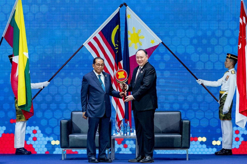 Defence Minister Datuk Seri Mohamed Khaled Nordin passes the Asean emblem to Philippines Defence Secretary Gilberto Teodoro during the chairmanship handover ceremony of the Asean Defence Ministers Meeting (ADMM) at the Kuala Lumpur Convention Centre, Kuala Lumpur, on November 1, 2025. — Picture by Firdaus Latif.