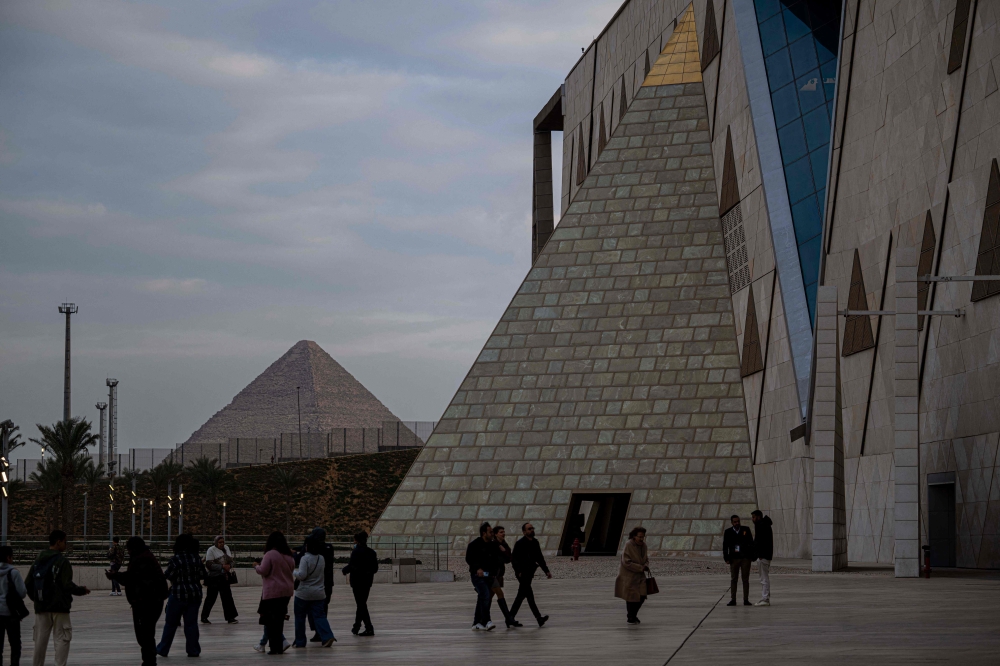 Visitors walk outside the Grand Egyptian Museum in Giza on the southwestern outskirts of the capital Cairo set to open fully on November 1, 2025, after years of delays caused by political instability, economic crises and the global pandemic. — AFP
