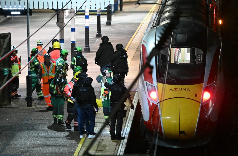 Police officers and members of the Emergency services work alongside an LNER Azuma train at Huntingdon Station following a stabbing on a train in Huntingdon, eastern England November 1, 2025. — AFP pic