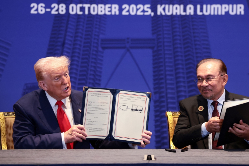 US President Donald Trump and Malaysian Prime Minister Anwar Ibrahim hold up trade deal documents during a bilateral meeting during the 47th Association of South-east Asian Nations (Asean) summit in Kuala Lumpur October 26, 2025. — Reuters pic