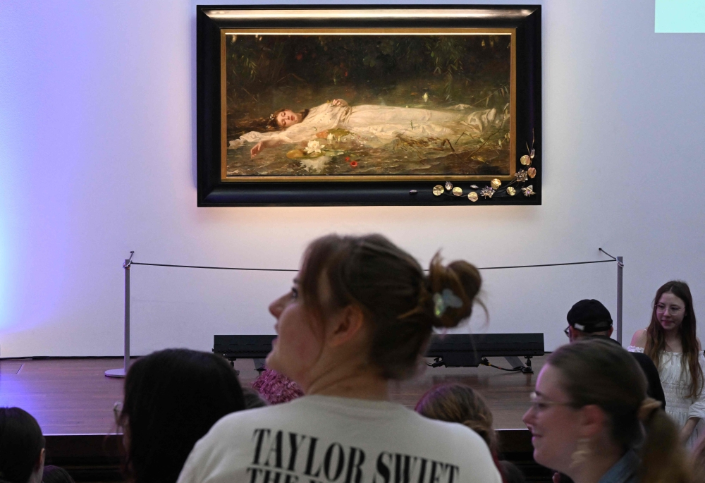 Fans of US singer-songwriter Taylor Swift and other visitors listen to a lecture about the painting ‘Ophelia’ (ca 1900) by German artist Friedrich Heyser during a short guided tour at the Museum in Wiesbaden, western Germany on November 2, 2025. — AFP pic 