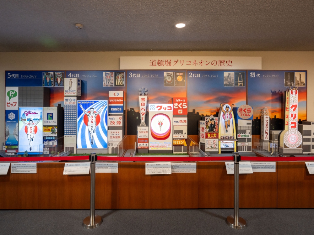 The first five generations of Glico Goal-in-Mark neon tower in miniatures being displayed at the Glico Museum in Osaka. -— Picture courtesy of Ezaki Glico Ltd