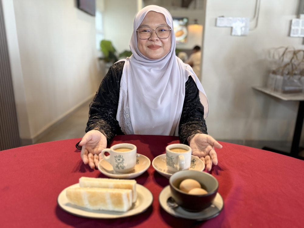 Kelab Kopi Lama chief executive officer Nur Syazwani Mohd Hassan showcases the Berangan Latte, a unique drink combining Arabica coffee and chestnuts, at Kelab Kopi Lama kopitiam in Kulai, Johor, November 3, 2025. — Bernama pic  