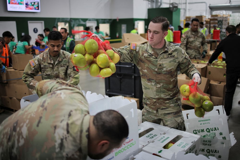 A member of the National Guard packs food at a Los Angeles Regional Food Bank facility as nearly 42 million people are set to lose food aid due to the second-longest US government shutdown in Los Angeles, California, US, October 29, 2025. — AFP pic