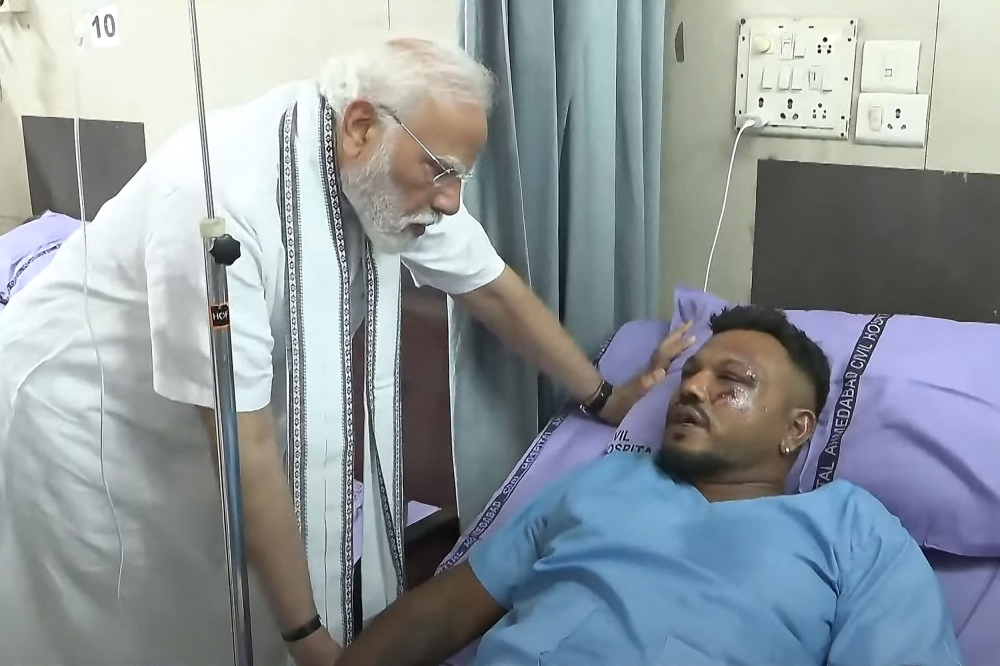 This screengrab of video footage taken and released by the Narendra Modi Youtube Channel on June 13, 2025 shows India's Prime Minister Narendra Modi (left) meeting with Vishwash Kumar Ramesh, sole survivor of the Air India flight 171 crash, at a hospital in Ahmedabad. — YouTube screenshot via AFP