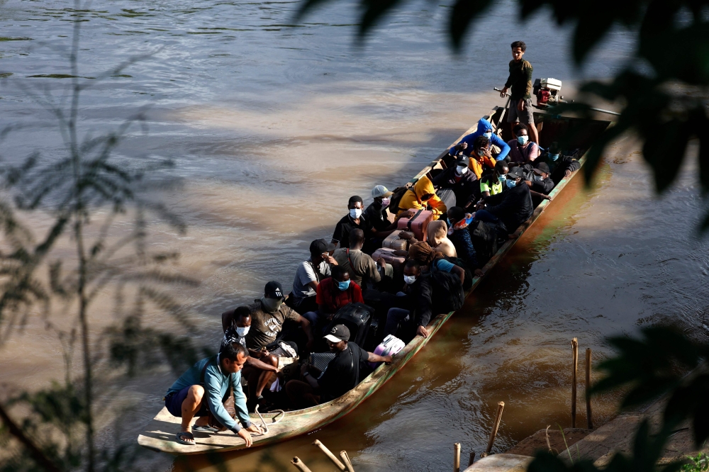 People from various countries, who were working in the KK Park compound in Myanmar, travel in a boat across the Moei river to cross over from Myanmar to Thailand, as seen from Mae Sot District, Tak Province area on October 24, 2025. — AFP pic