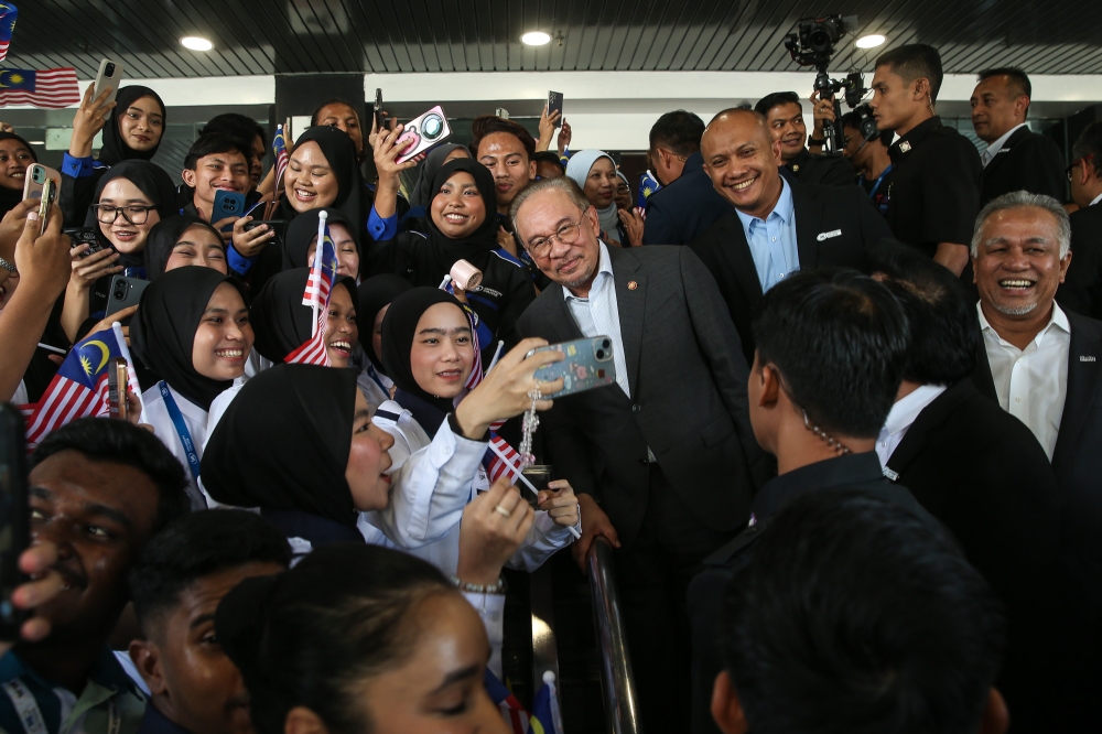 Prime Minister Datuk Seri Anwar Ibrahim takes photos with students while he attends the launch of the IJN University College in Kuala Lumpur on November 4, 2025. — Picture by Yusof Isa