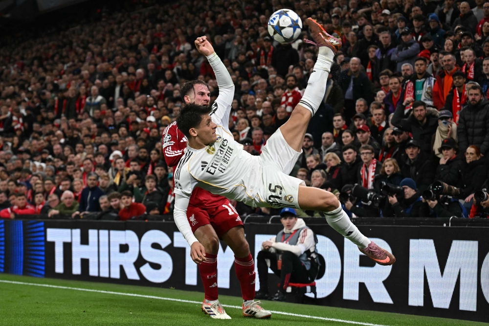 Real Madrid’s Turkish midfielder #15 Arda Guler ® vies with Liverpool’s Argentinian midfielder #10 Alexis Mac Allister (L) during the UEFA Champions League, league phase football match between Liverpool and Real Madrid at Anfield in Liverpool, north west England on November 4, 2025. — AFP pic