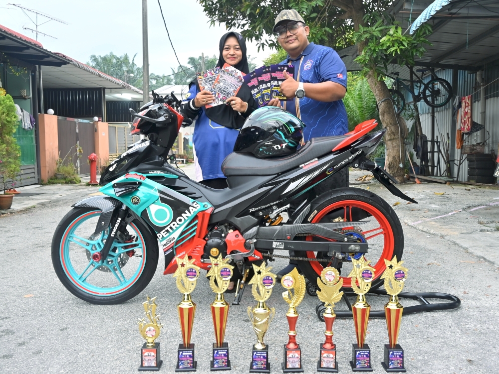 Wahyu Hidayat Japar and his wife Rozieana Abd Kadir with the Yamaha 135LC once owned by his late brother-in-law, now an award-winning motorcycle he considers lucky. — Bernama pic