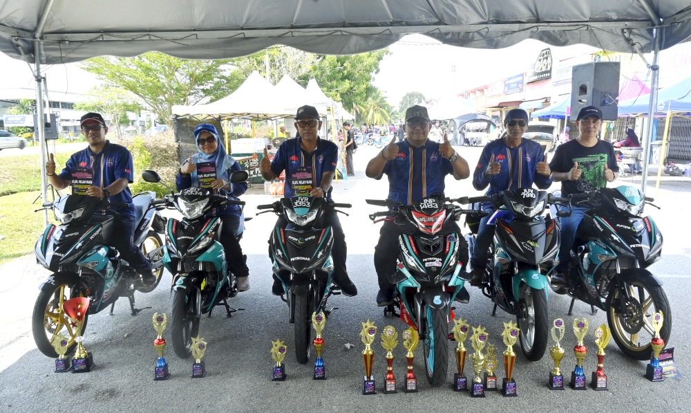 Wahyu Hidayat Japar (third right) and members of the Petronas Santai Moto Tongkang Pechah group show off trophies won at a recent bikeshow in Taman Bistari, Batu Pahat. — Bernama pic