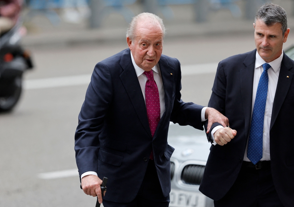 Spain's former King Juan Carlos I is helped as he arrives at the wedding of Madrid's Mayor Jose Luis Martinez Almeida (not seen), at Sagrado Corazon y San Francisco de Borja church in Madrid April 6, 2024. — AFP pic