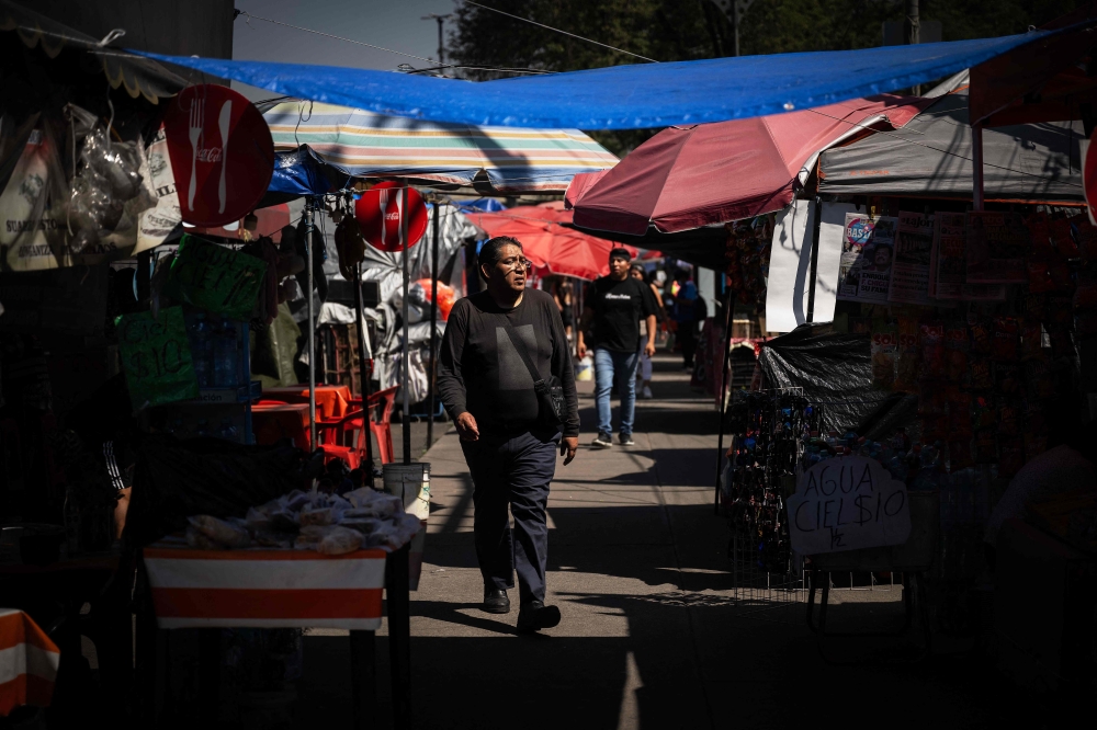 People walk past food stalls outside the Azteca Stadium in Mexico City on October 28, 2025. — AFP pic 