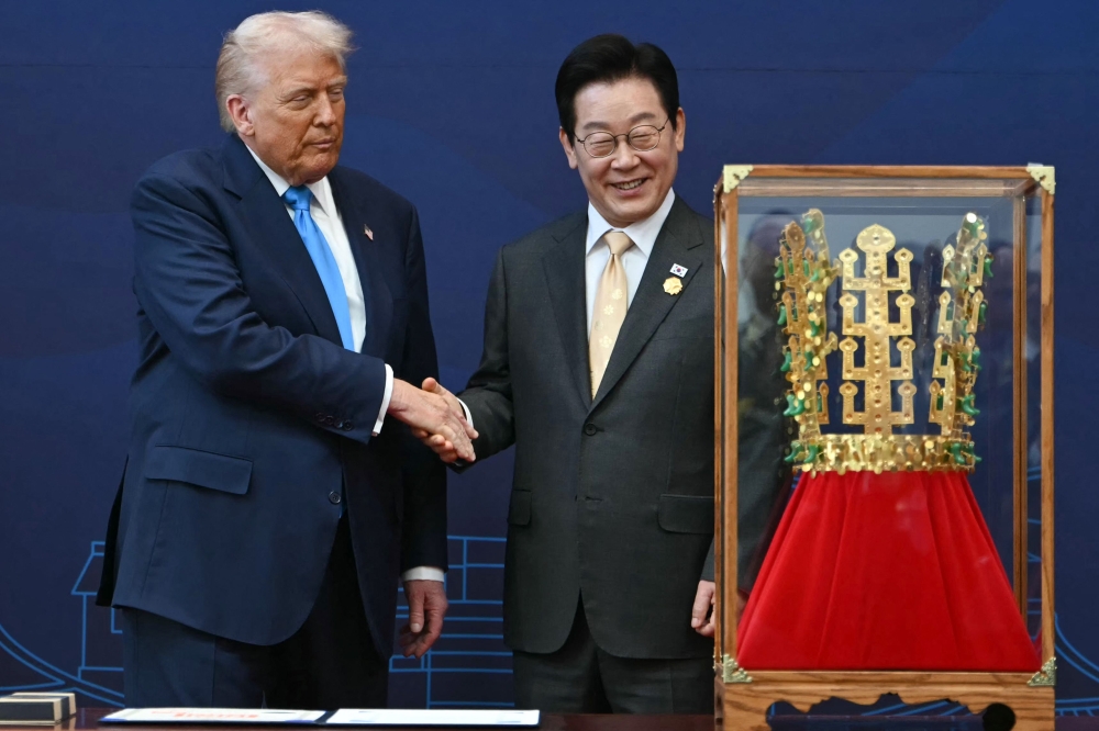 US President Donald Trump (left) shakes hands with South Korean President Lee Jae Myung during a high honor presentation ceremony, where Trump was presented with a replica of a crown worn by the kings of Silla, at the Gyeongju National Museum in Gyeongju on October 29, 2025. — AFP file pic
