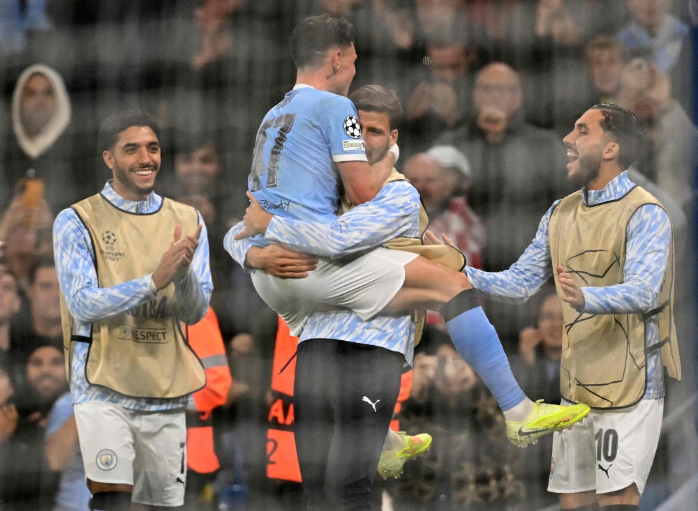 Manchester City’s Phil Foden jump-hugs Ruben Dias after scoring against Borussia Dortmund in the Champions League, November 5, 2025. — AFP pic