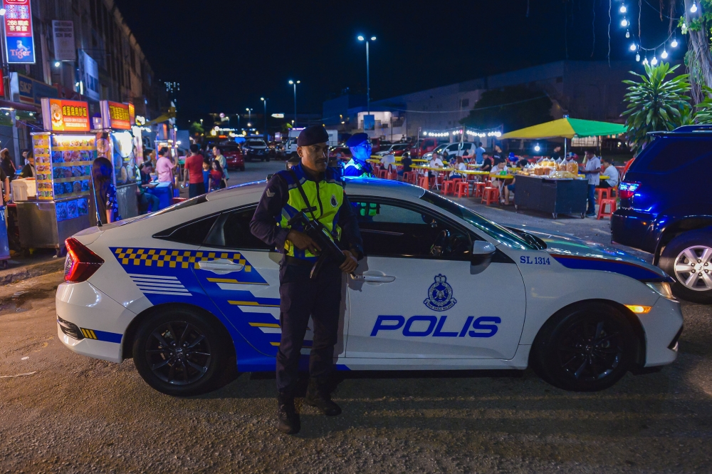 Police officers investigate the scene where a man, believed to be a foreign national, was found dead at a shoplot staircase in Puchong Jaya, Serdang last night. — Bernama pic