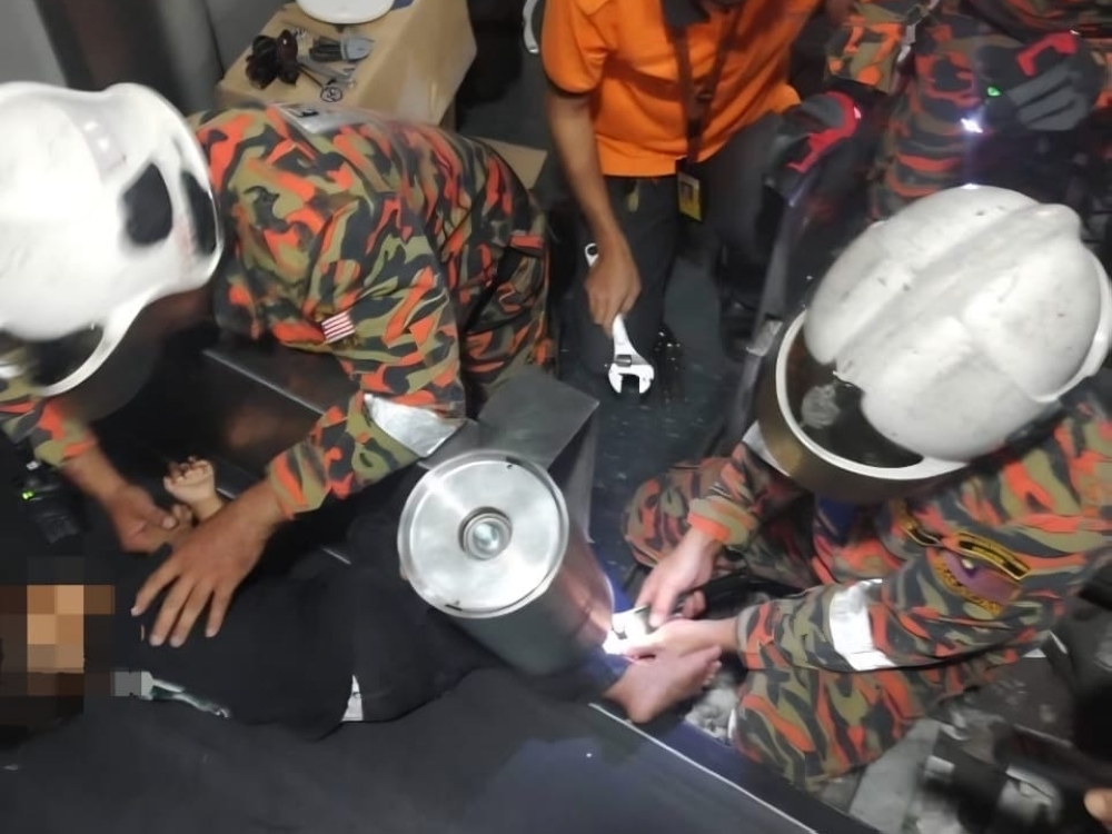 Firefighters used special equipment to free the boy before both children were handed over to paramedics and taken to Likas Hospital for examination and further treatment. — Picture via Facebook