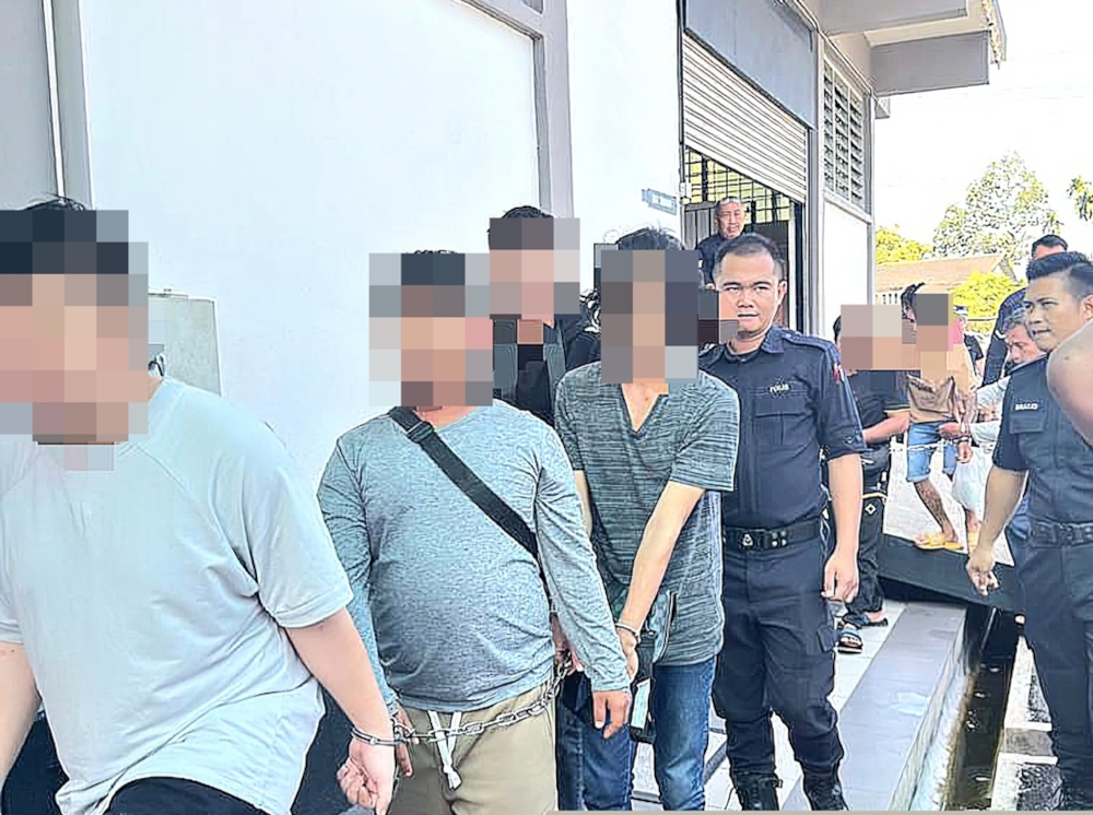 Some of the 221 detainees arrested during Sibu police’s month-long Op Tapis Narkotik are escorted to court. — The Borneo Post pic 