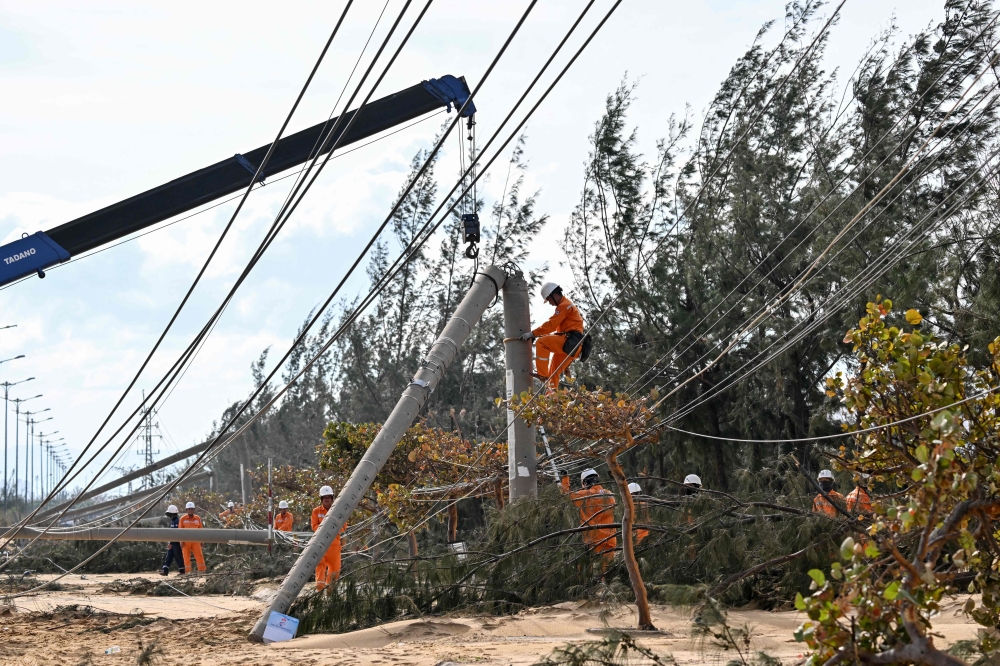 An electricity crew works on downed power lines to restore services in the aftermath of Typhoon Kalmaegi in Gia Lai province, central Vietnam on November 7, 2025. — AFP pic 