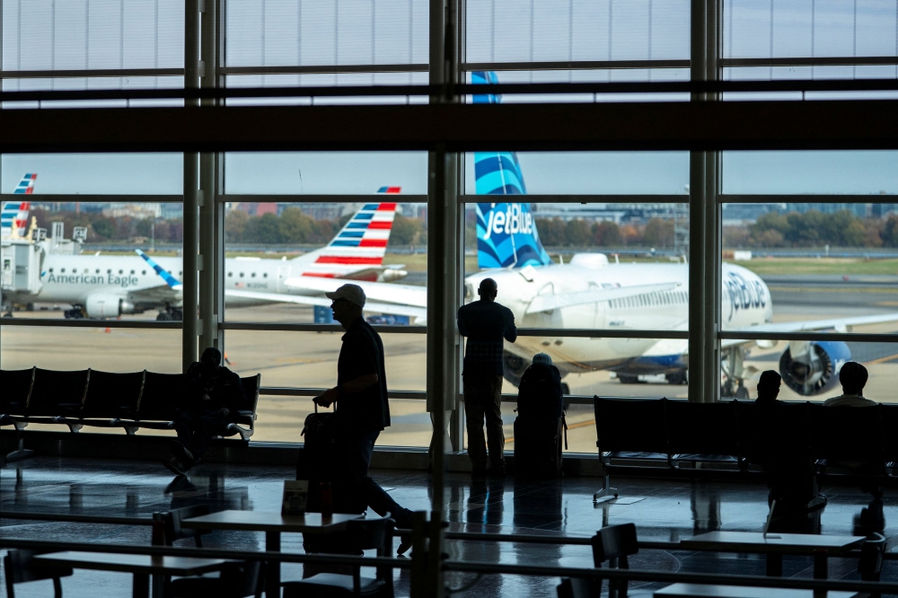Travelers walk though Ronald Reagan Washington National Airport as the Trump administration warns of impending cuts to commercial airline operations more than a month into the continuing US government shutdown in Arlington, Virginia November 7, 2025. — Reuters pic