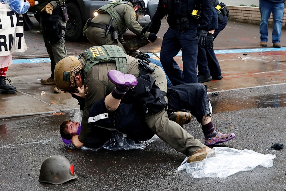 A federal officer detains a protester during a ‘World Naked Bike Ride’ protest against increased activity by US Immigration and Customs Enforcement (ICE) and potential National Guard deployment in Portland, Oregon October 12, 2025. — Reuters pic  