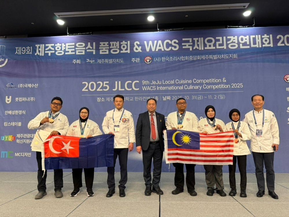Muhammad Saufie Ab Rashid and Fazalina Ismail hold their home state flag of Johor after winning bronze with Cucur Udang Kuah Kacang at the Ninth Jeju Local Cuisine Competition & WACS International Culinary Competition 2025. — Picture from Facebook/Cikda Cook House
