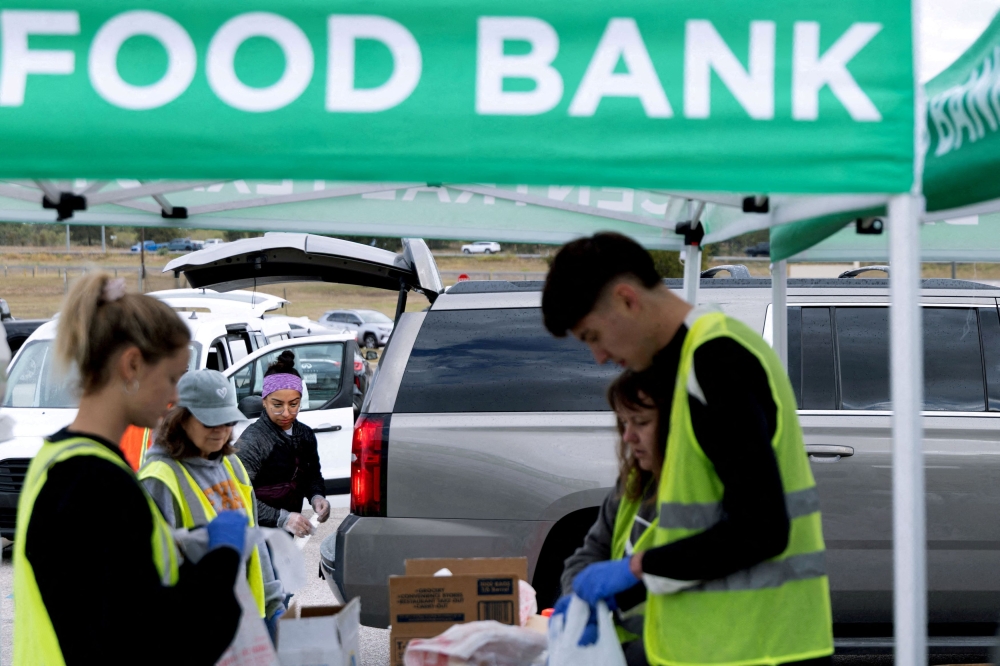 Volunteers place food items in vehicles during a mobile food distribution at Cedar Creek High School, as nearly 42 million Americans face a potential lapse in Supplemental Nutrition Assistance Programme (SNAP) benefits, known as food stamps, due to the second-longest US government shutdown, in Cedar Creek, Texas November 1, 2025. — Reuters pic  