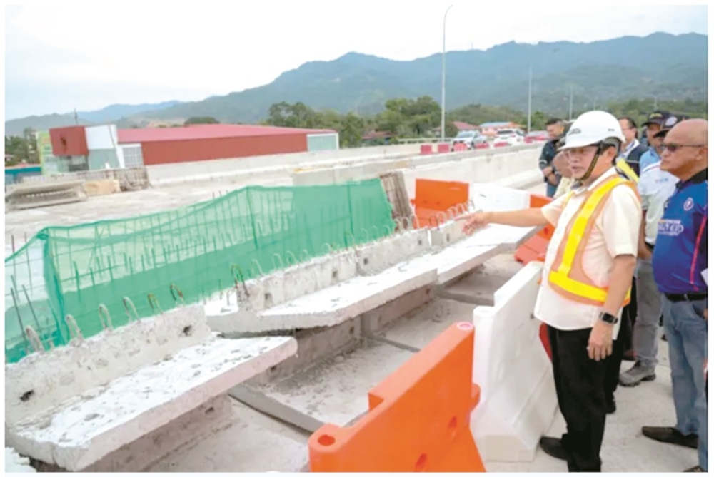 Maslan being briefed on the alignment and progress of the Pan Borneo Highway project by Public Works Department. — Daily Express pic