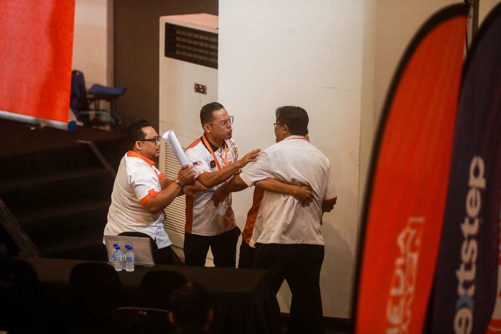 A delegate is escorted out of the hall after provoking one of the debaters during the 2025 Amanah National Convention in Shah Alam November 10, 2025. — Picture by Sayuti Zainudin