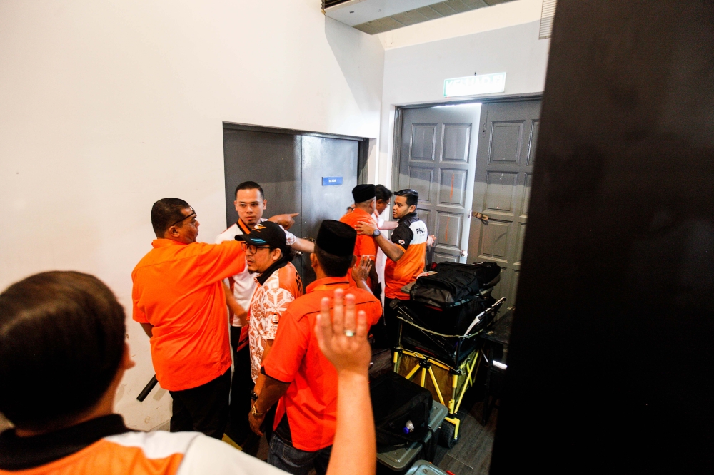 A delegate is escorted out of the hall after provoking one of the debaters during the 2025 Amanah National Convention in Shah Alam November 10, 2025. — Picture by Sayuti Zainudin