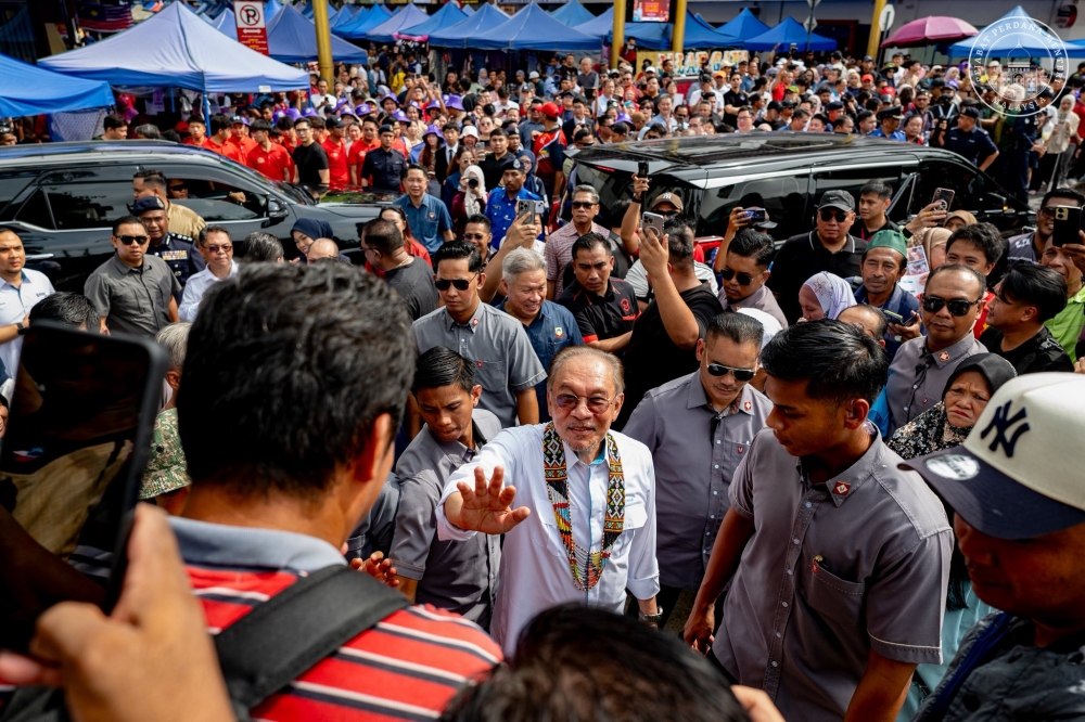 Prime Minister Anwar Ibrahim gestures during a walkabout at the Gaya Street Sunday Market in Kota Kinabalu November 9, 2025. — Picture via Facebook/Anwar Ibrahim