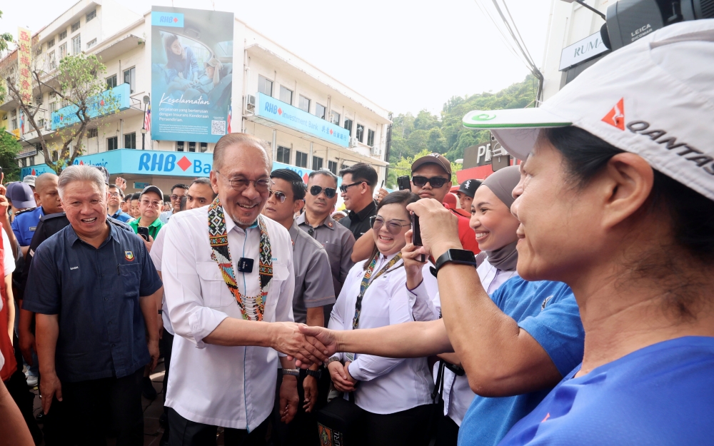 Prime Minister Anwar Ibrahim mingles with visitors during a walkabout at the Gaya Street Sunday Market in Kota Kinabalu November 9, 2025. — Bernama pic