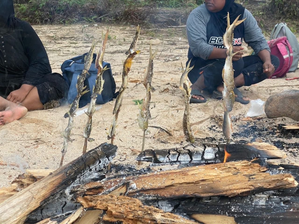 After catching fish in the rushing river with the Batek Nong tribe (Negrito), they cooked their catch over a barbecue and enjoyed a riverside picnic together. — Picture courtesy of Happy Campers Productions