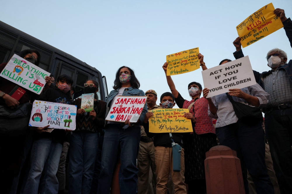 Protesters hold placards in front of the India Gate during a protest against air pollution in New Delhi November 9, 2025. — Reuters pic