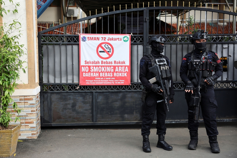 Armed police personnel stand guard outside an area after an explosion occurred at a school complex in Jakarta November 7, 2025. — Reuters pic