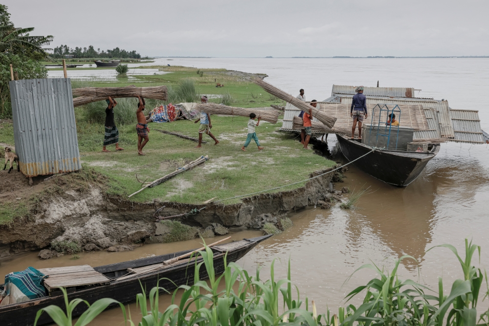 Relatives and neighbours help move the house of Kosim Uddin, 50, to another island in the Brahmaputra River, as the current one is on the verge of being destroyed by erosion, in Kurigram, Bangladesh, June 20, 2024. — Reuters pic 