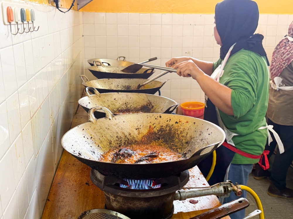 A row of woks inside the shoplot where workers deep fry the fish in batches. — Picture by Lee Khang Yi

