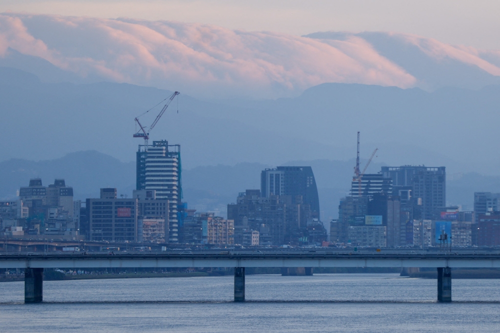 A view of the Taipei skyline with clouds hanging over distant mountains, seen from across the Tamsui River in Taipei November 8, 2025. Taiwan evacuated more than 8,300 people ahead of today’s arrival of a much weakened Typhoon Fung-wong that brought heavy downpours to the mountainous east coast and unleashed floods that ran neck-high in places. — Reuters pic