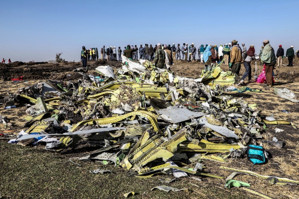 People stand near collected debris at the crash site of Ethiopia Airlines near Bishoftu, a town some 60 kilometres southeast of Addis Ababa, Ethiopia, on March 11, 2019. — AFP file pic