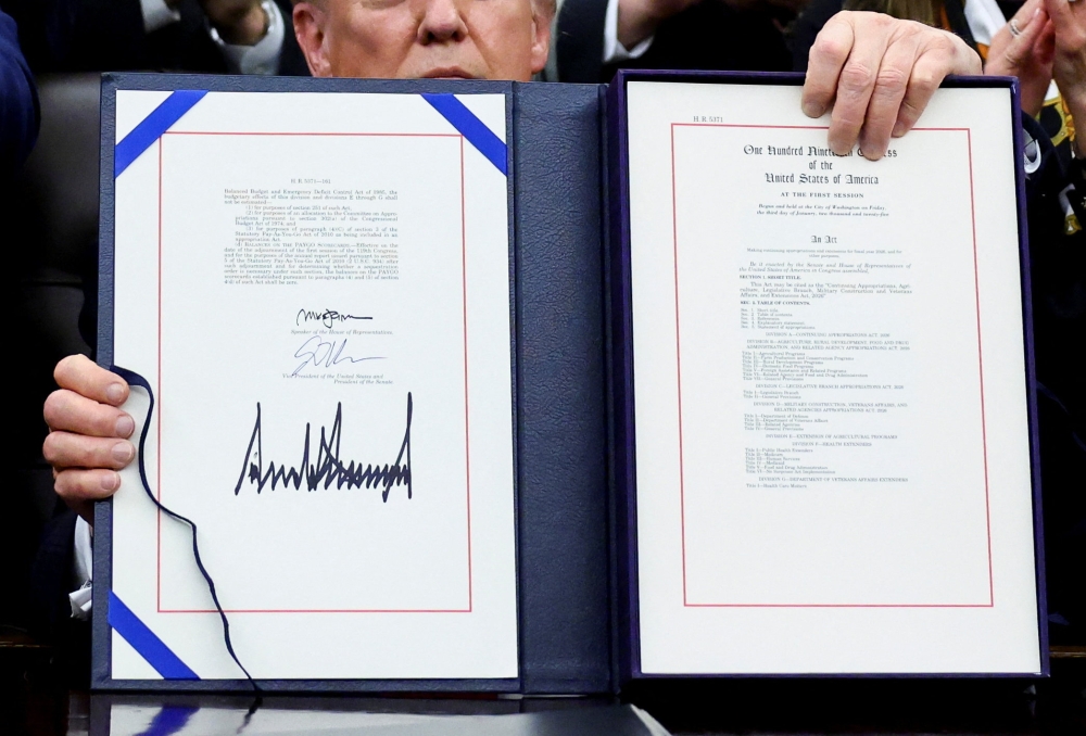 US President Donald Trump poses for a photo after he signs the funding bill to end the US government shutdown, at the White House in Washington, D.C. November 12, 2025. — Reuters pic 