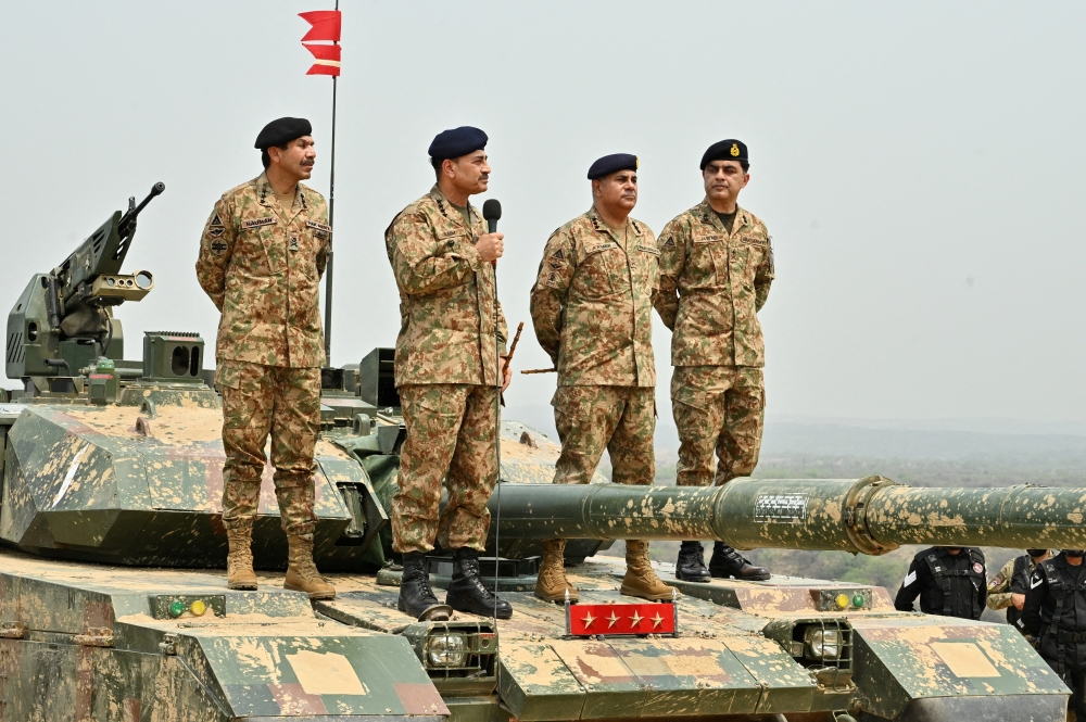 Chief of Army Staff of Pakistan Asim Munir holds a microphone during his visit at the Tilla Field Firing Ranges to witness the Exercise Hammer Strike, a high-intensity field training exercise conducted by the Pakistan Army's Mangla Strike Corps, in Mangla, Pakistan May 1, 2025.  — Inter-Services Public Relations handout pic via Reuters 