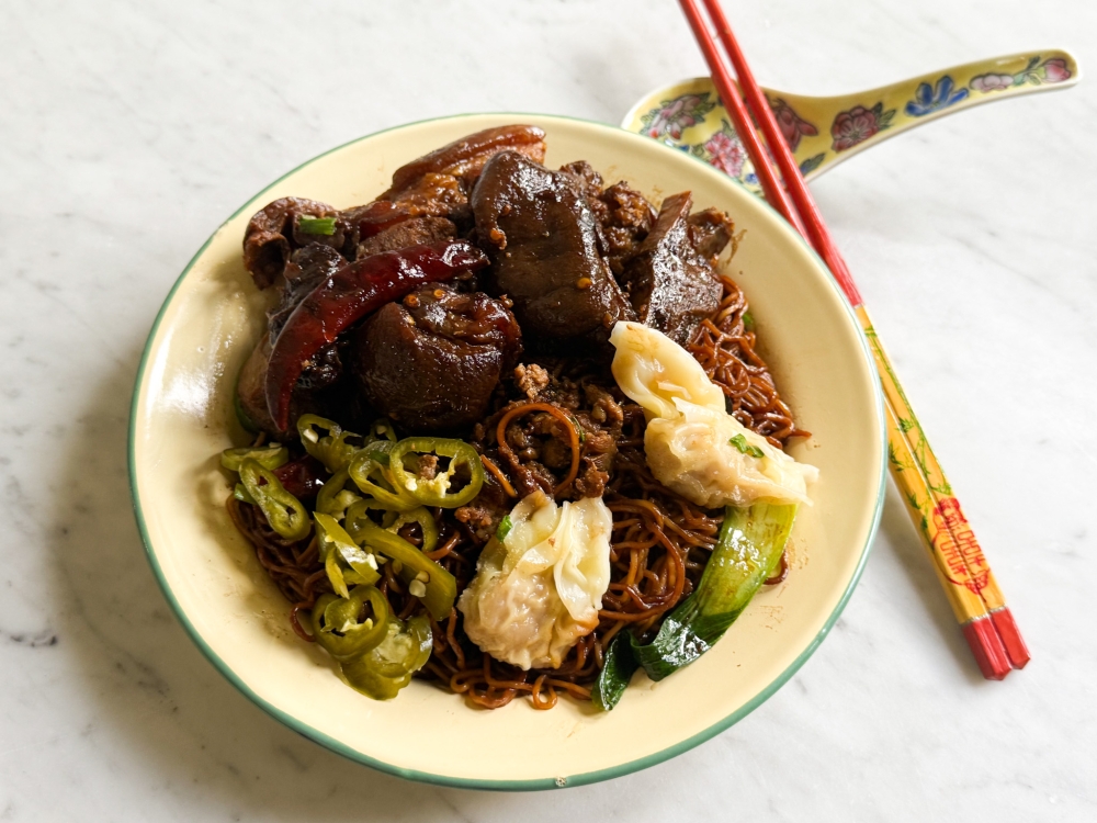 My fully loaded plate of egg noodles, braised pork leg and ‘wantans’ together with pickled green chillies which I relished at home. — Picture by Lee Khang Yi