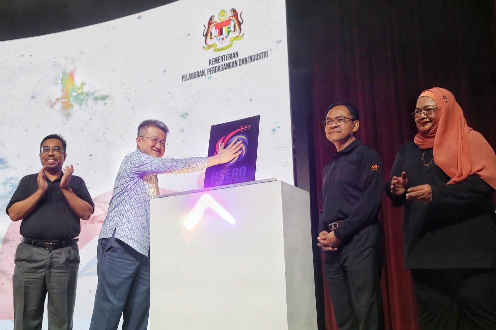 Deputy Investment, Trade and Industry Minister Liew Chin Tong (second left) takes part in an opening gimmick for Asean Miti Day at the ministry in Kuala Lumpur today. — Picture by Choo Choy May.
