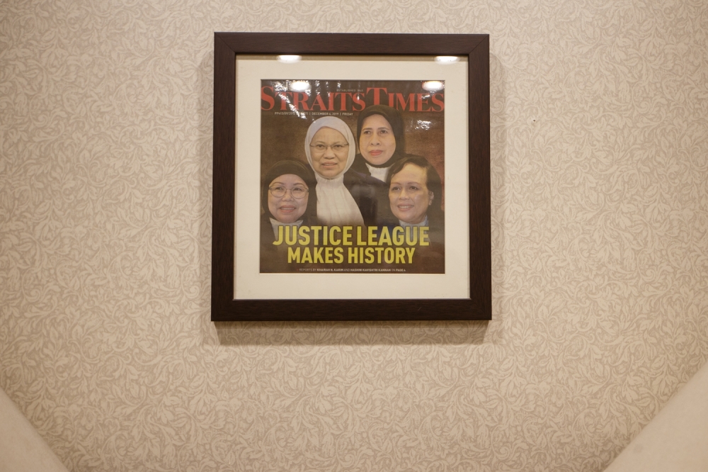 A 2019 newspaper cutting with the headline ‘Justice League Makes History' hangs in Tan Sri Hasnah Mohammed Hashim's office, which was when she and two other women judges were promoted to be Federal Court judges and when Tan Sri Rohana Yusuf became the first woman to be the President of the Court of Appeal. — Picture by Raymond Manuel 