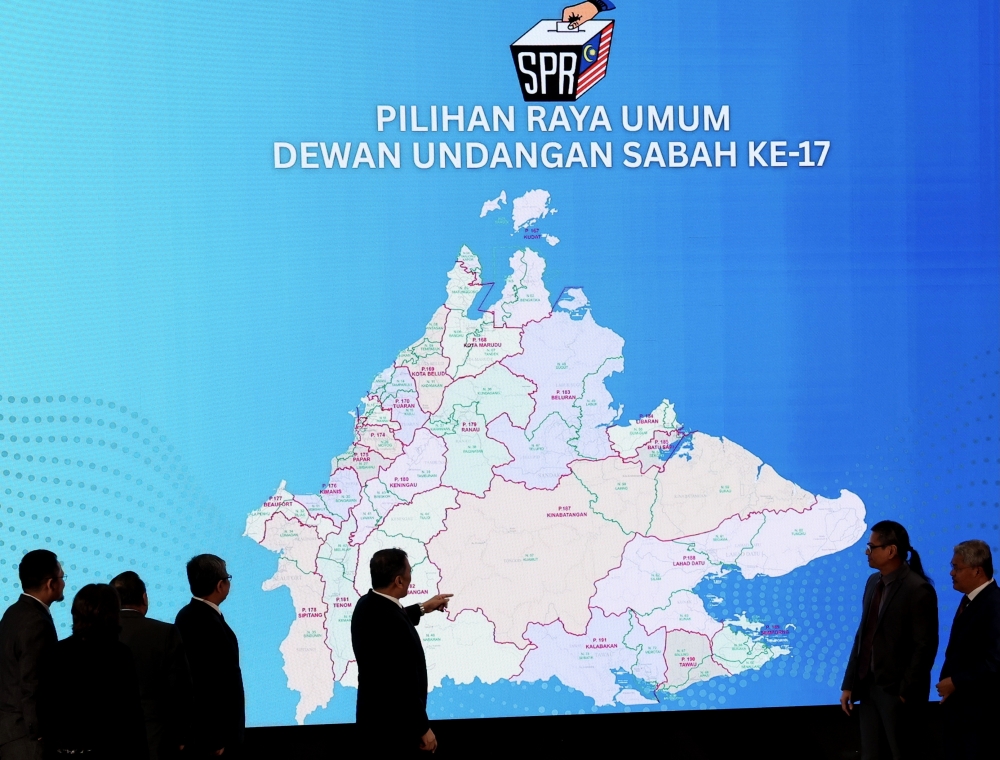 This file picture shows officials viewing the Sabah state constituency map during a press conference announcing key dates for the state election, Kota Kinabalu, October 16.— Bernama pic