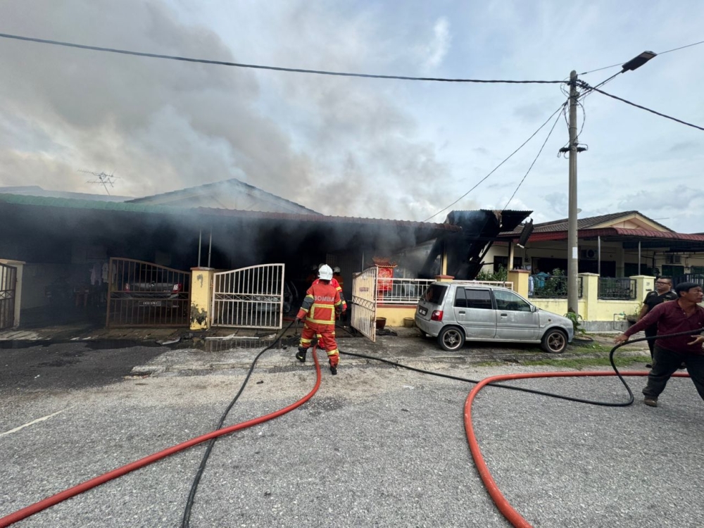 Firefighters at the scene after a blaze gutted an elderly man’s home in Taman Perpaduan Ria, damaging several neighbouring houses. — Picture via Facebook