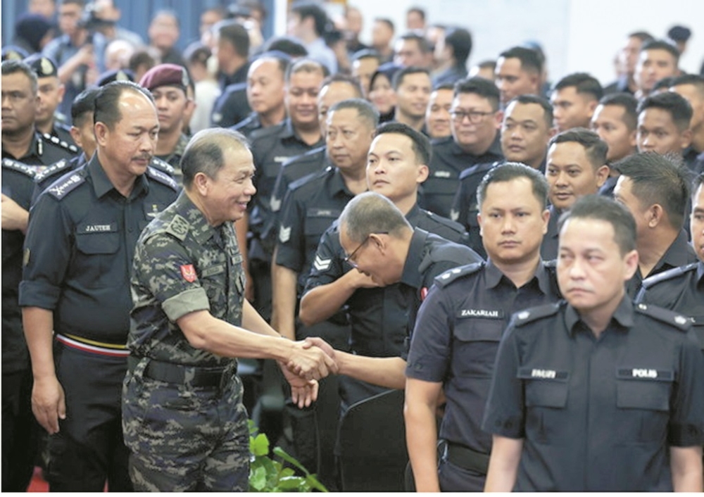 Mohd Khalid mingles with police officers at a special meeting with Royal Malaysia Police (PDRM) officers in conjunction with the 17th Sabah State Election. — Daily Express pic