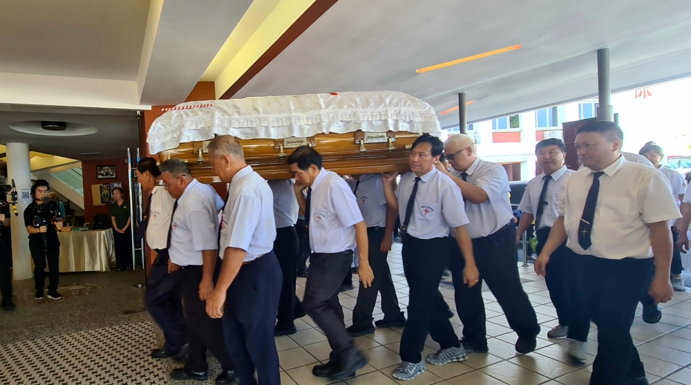 Pallbearers carrying Tan Sri Tiong’s casket as they arrive at New Masland Church for the funeral service. — The Borneo Post pic