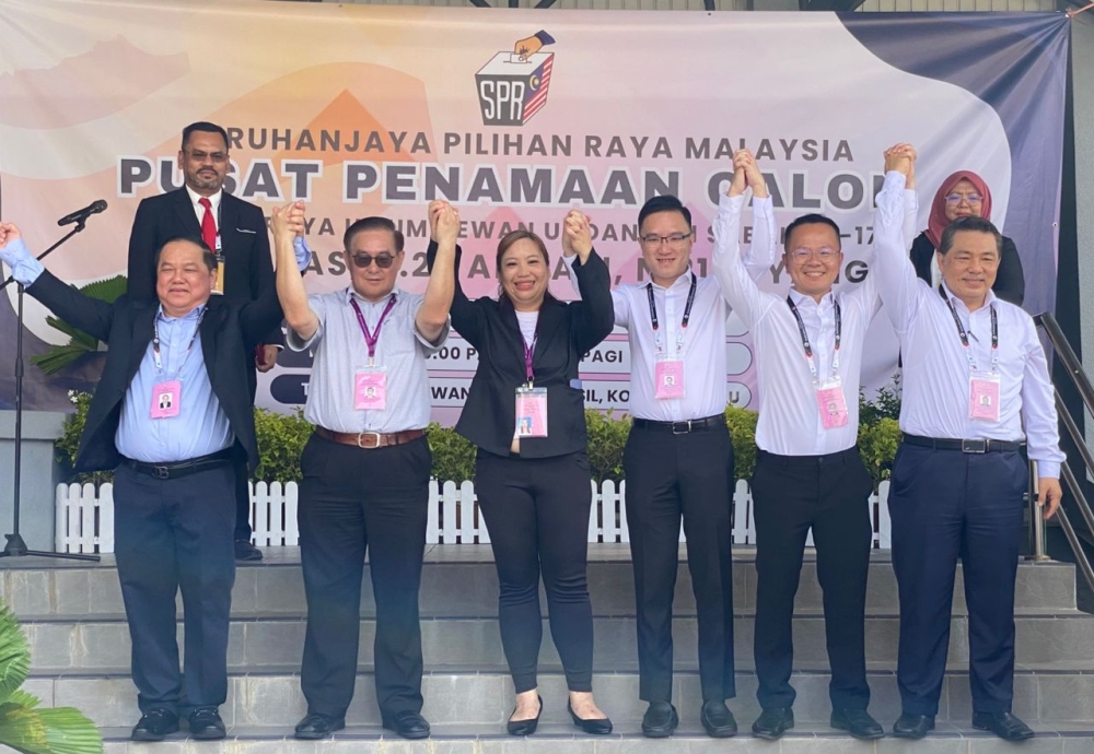 Abdul Mukti (back left) poses with the candidates for Likas. — The Borneo Post pic
