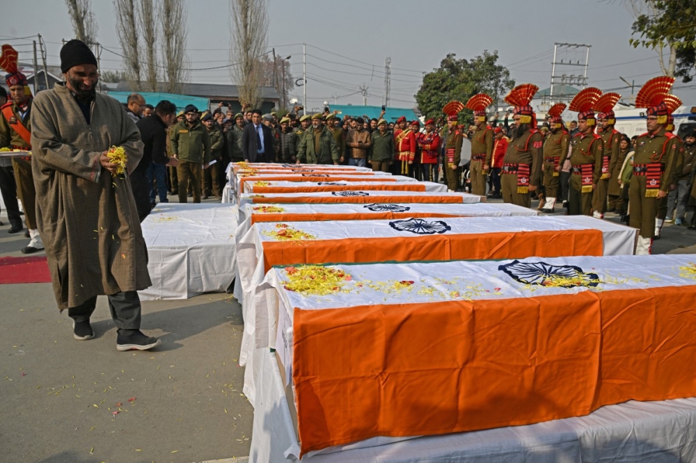 A relative mourns as he carries flowers during the wreath laying ceremony for the deceased victims in an accidental blast at Nowgam police station, on the outskirts of Srinagar, on November 15, 2025. — AFP pic